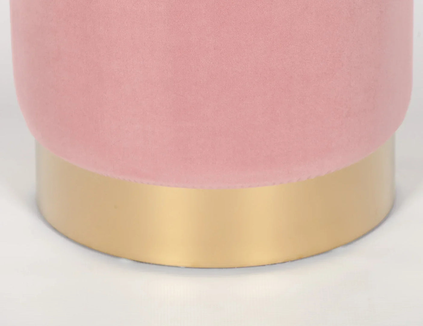 Pink velvet ottoman with brushed gold metal base, close detail view