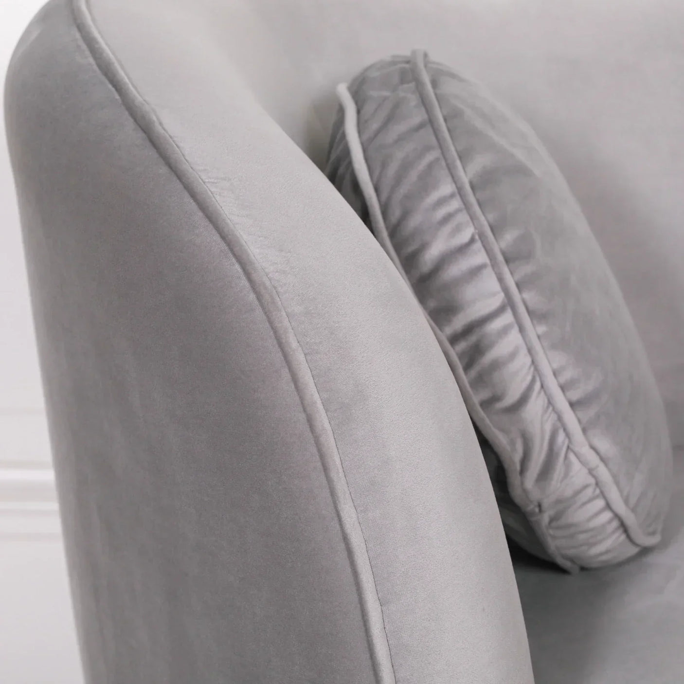 Light grey velvet sofa arm and cushion close-up