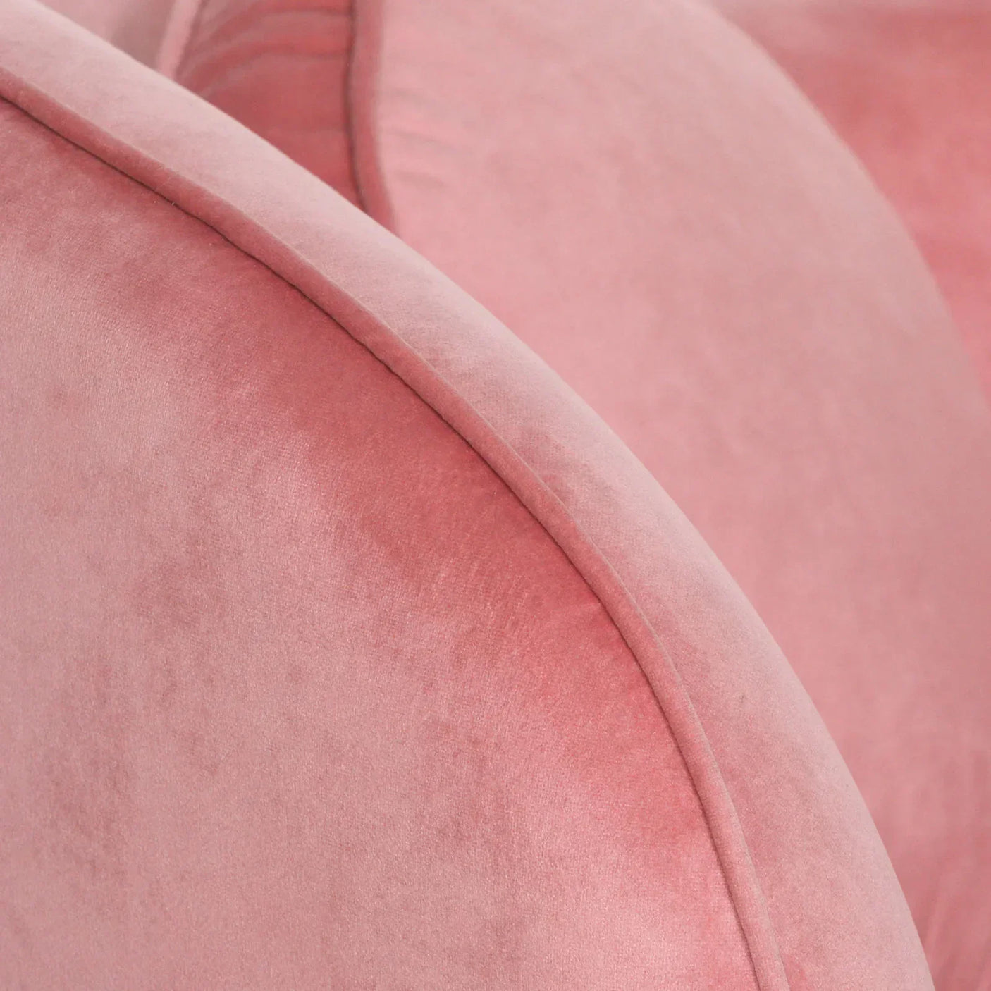 Closeup of pink velvet sofa arm and cushion highlighting upholstery texture