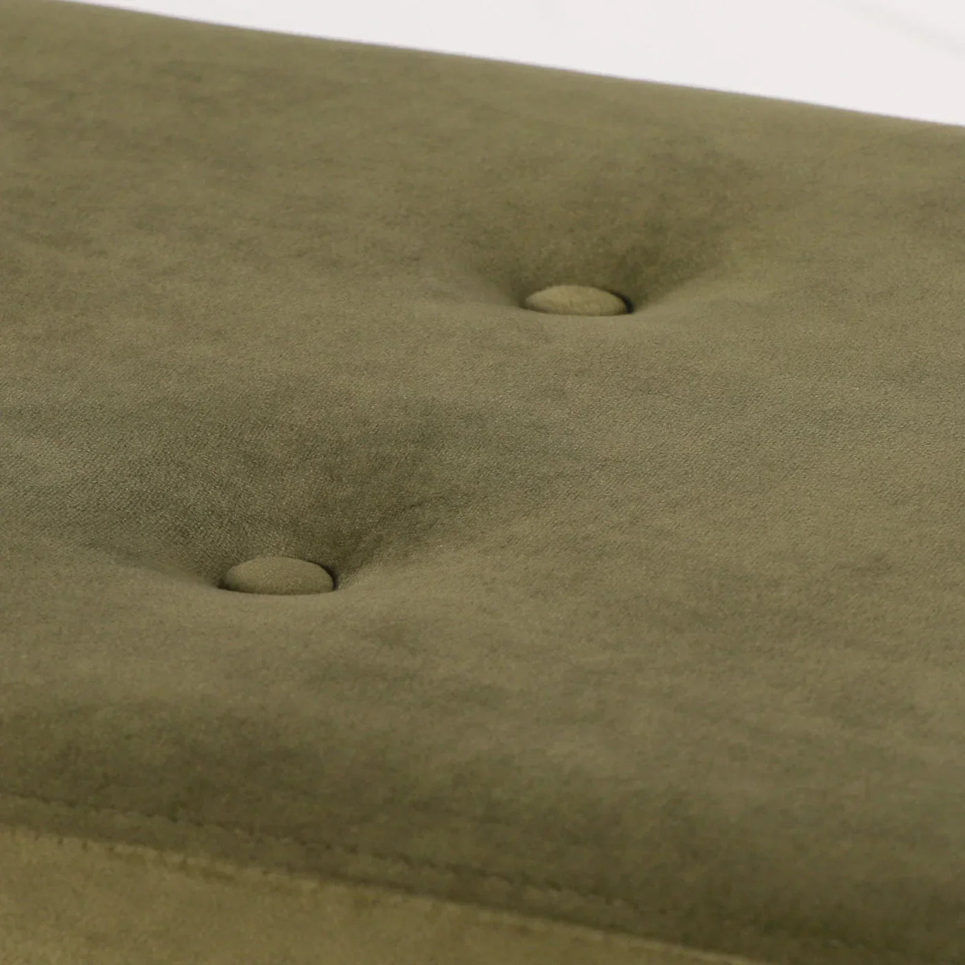 Olive green upholstered furniture seat with button tufting close-up
