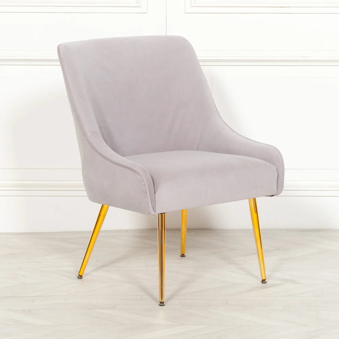 Grey accent chair with gold metal legs on wooden floor