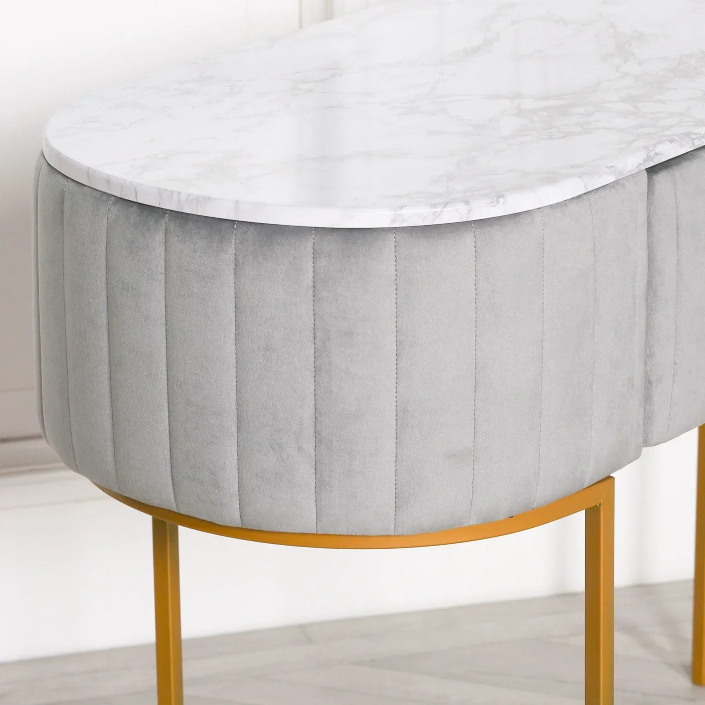 Grey velvet console table with white marble top and gold metal legs, close corner view