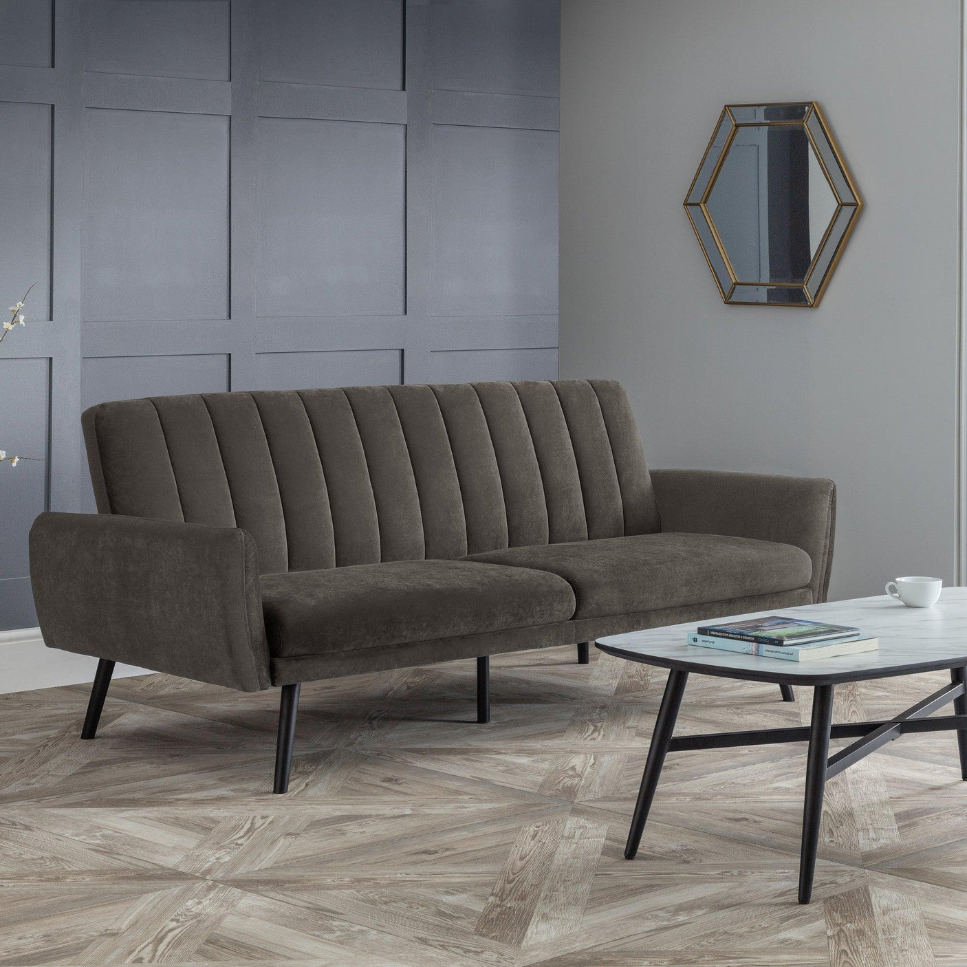 Grey sofabed with vertical stitching and black legs in modern living room setting