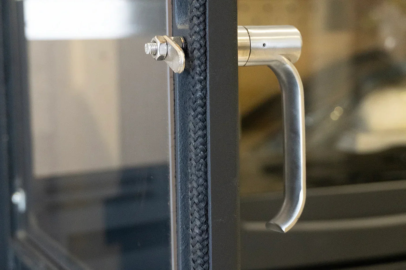 Alderwood stove door handle with brushed steel finish and braided rope seal gasket