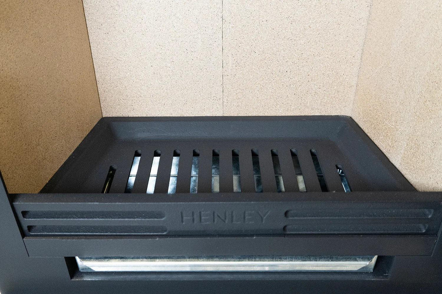Black stove firebox with metal grate and cream firebrick interior