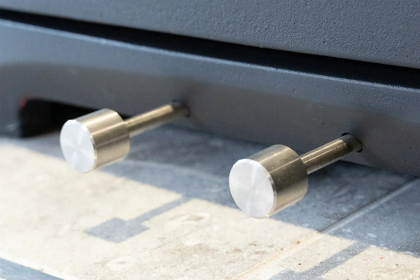 Alderwood pull handle pair in brushed metal finish mounted on door, close-up view