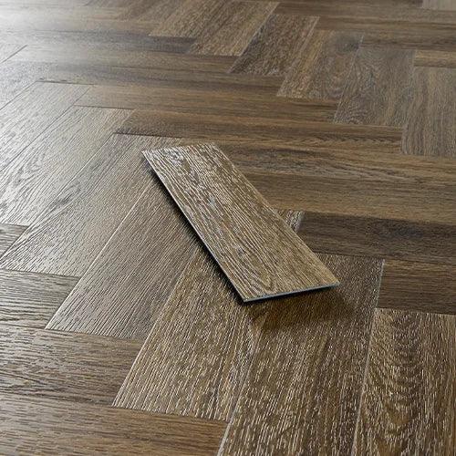 Antique walnut effect vinyl flooring in herringbone pattern with single plank detail