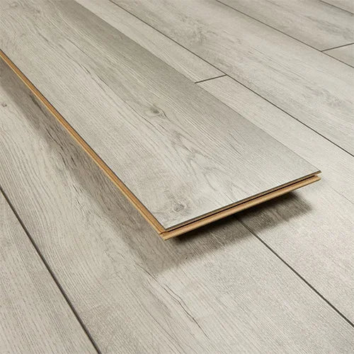 Light oak laminate flooring plank with wood grain texture on matching floor surface