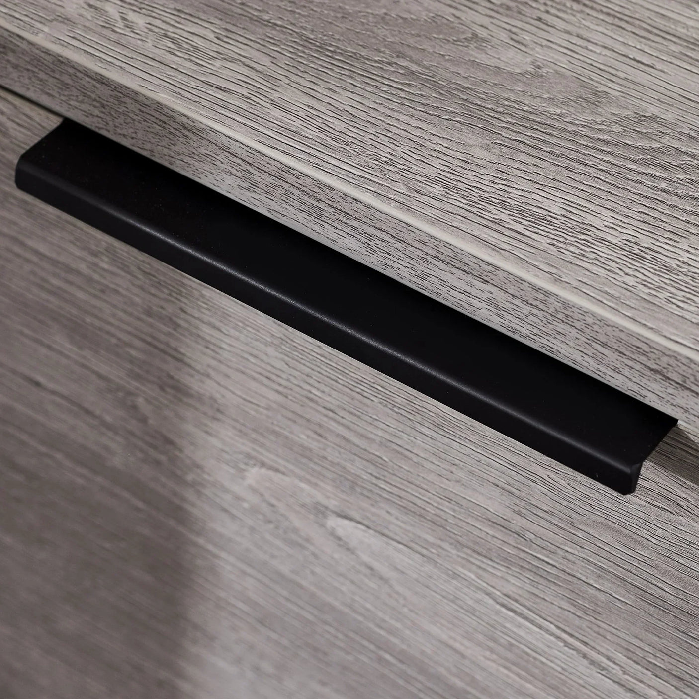 Grey oak drawer chest close-up showing black metal handle and wood grain texture