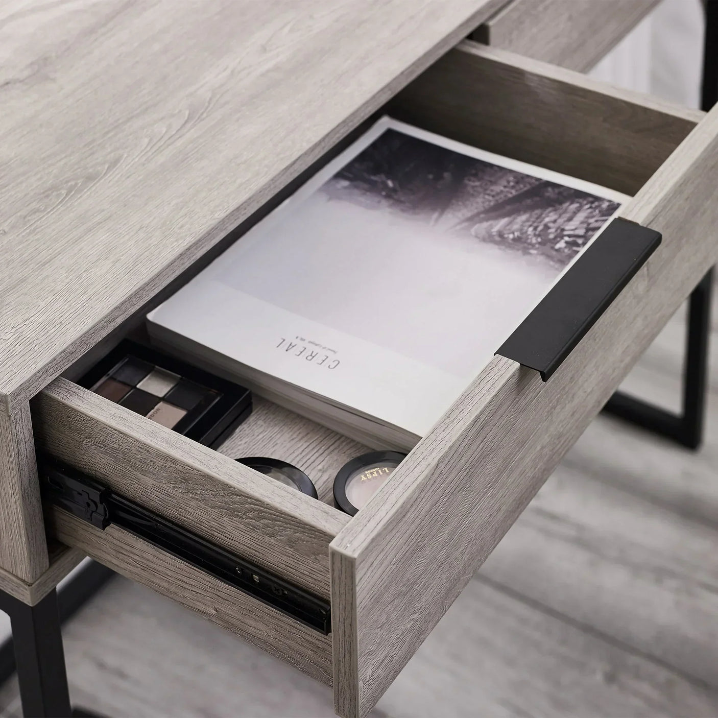 Grey oak dressing table desk drawer with metal handle, open to show organized storage compartments