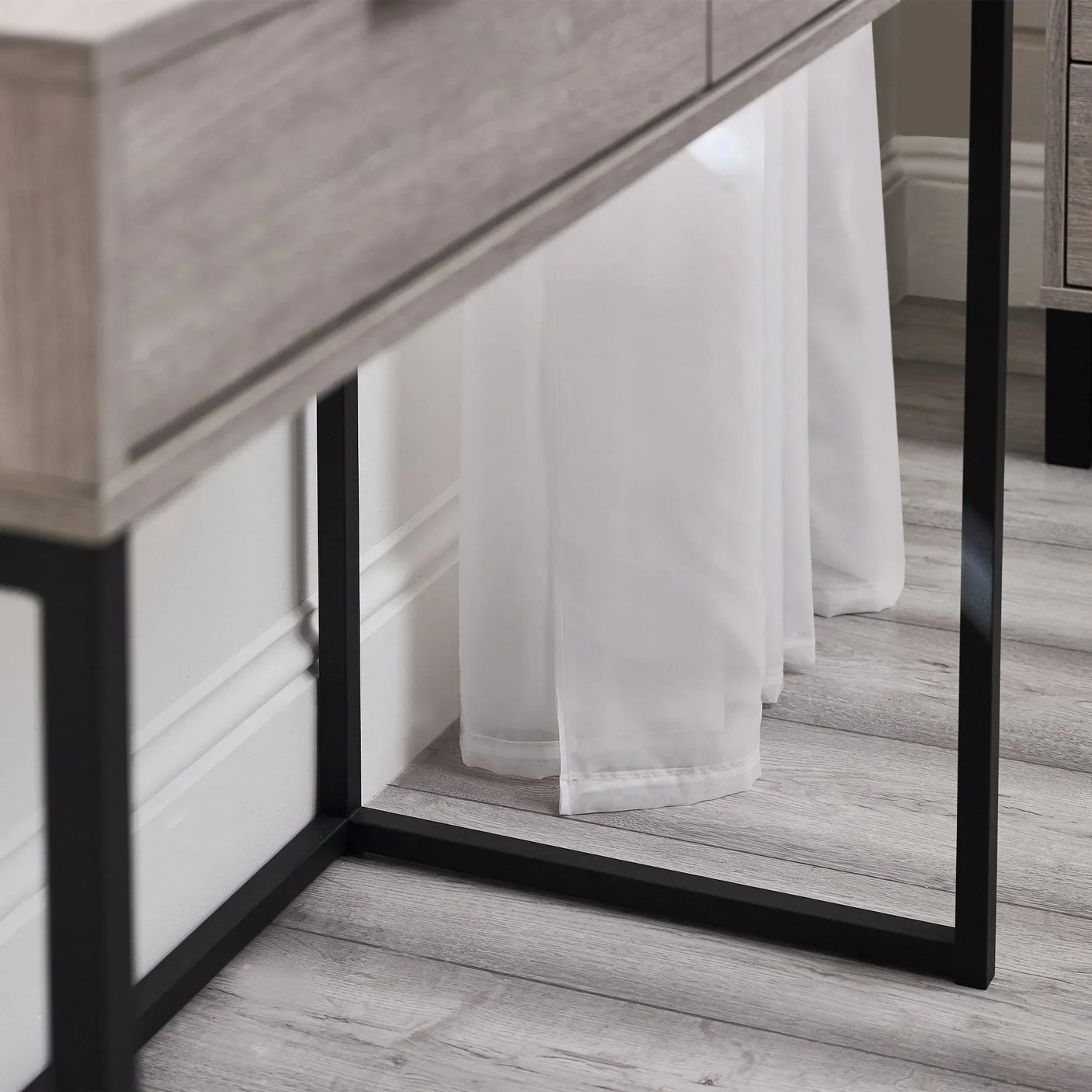 Grey oak dressing table desk with black metal legs close up on wood grain and frame