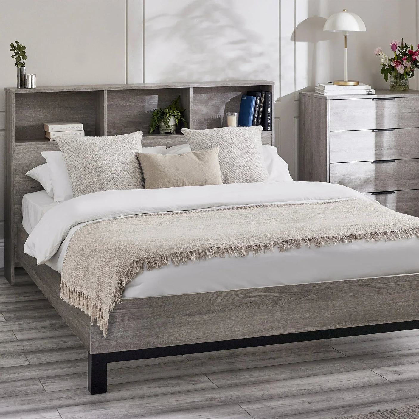 Grey oak bookcase headboard bed with storage, styled with cushions and bedside decor