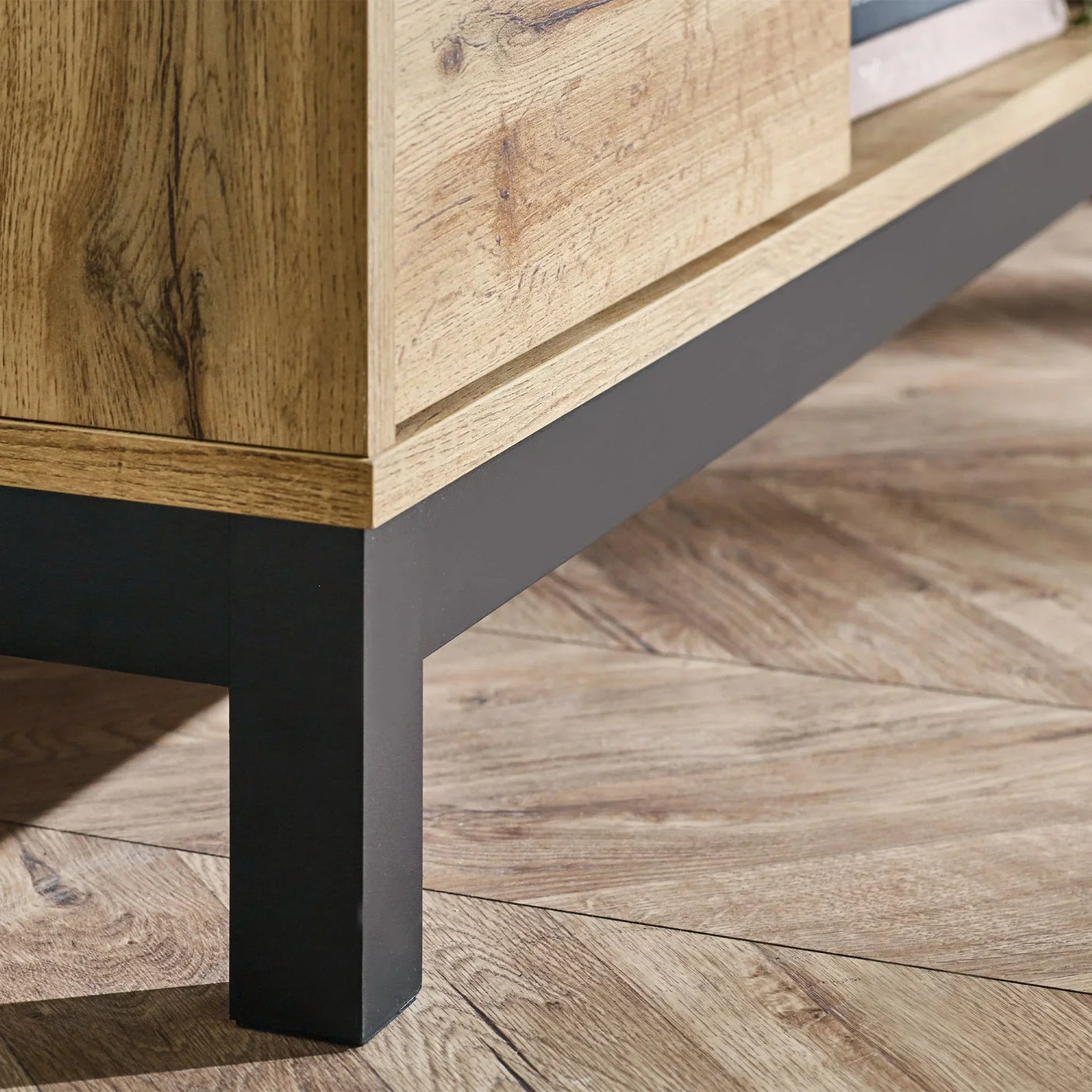 Light oak TV unit corner with black metal leg on wood floor