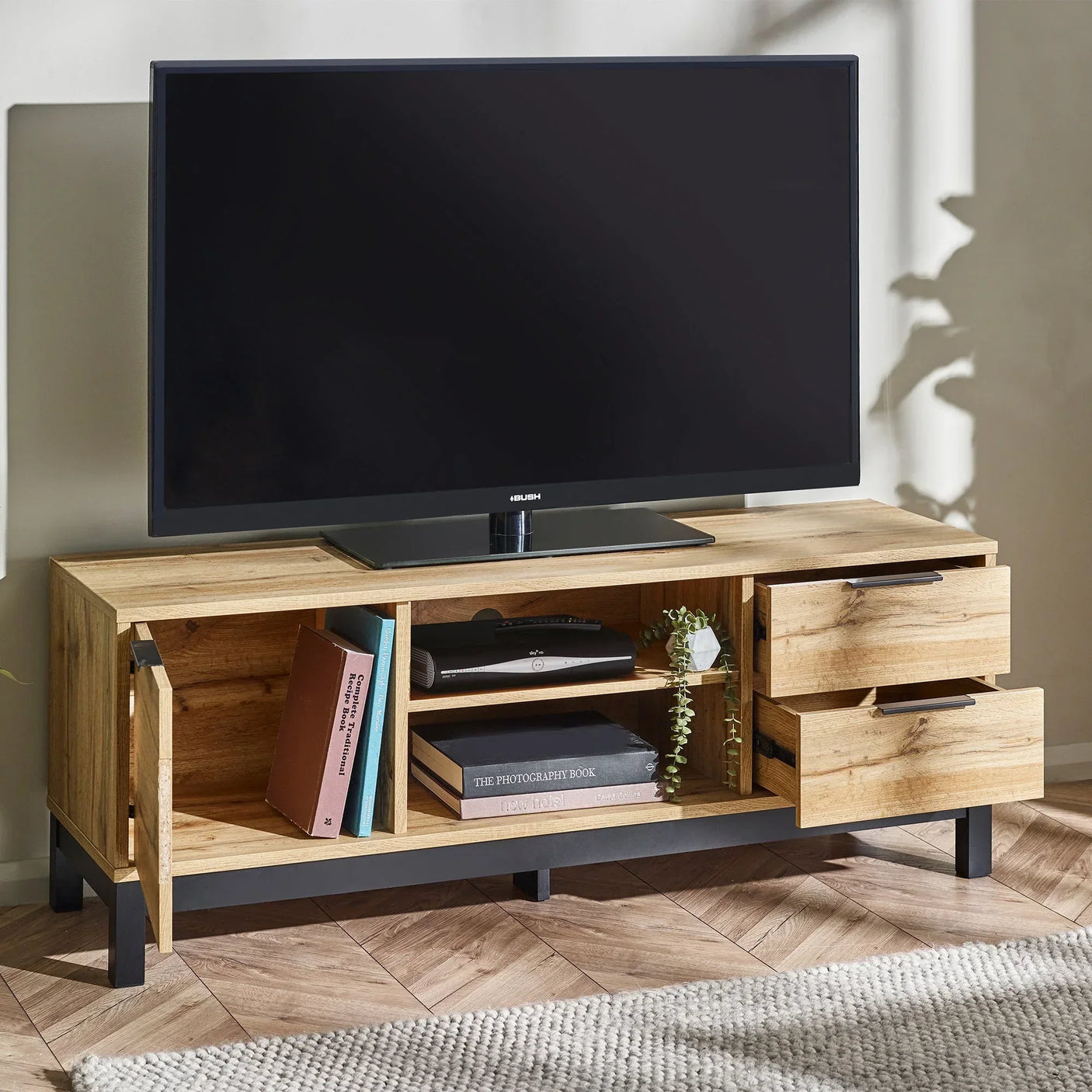 Light oak TV unit with shelves, two open drawers, books, and decor in modern living room