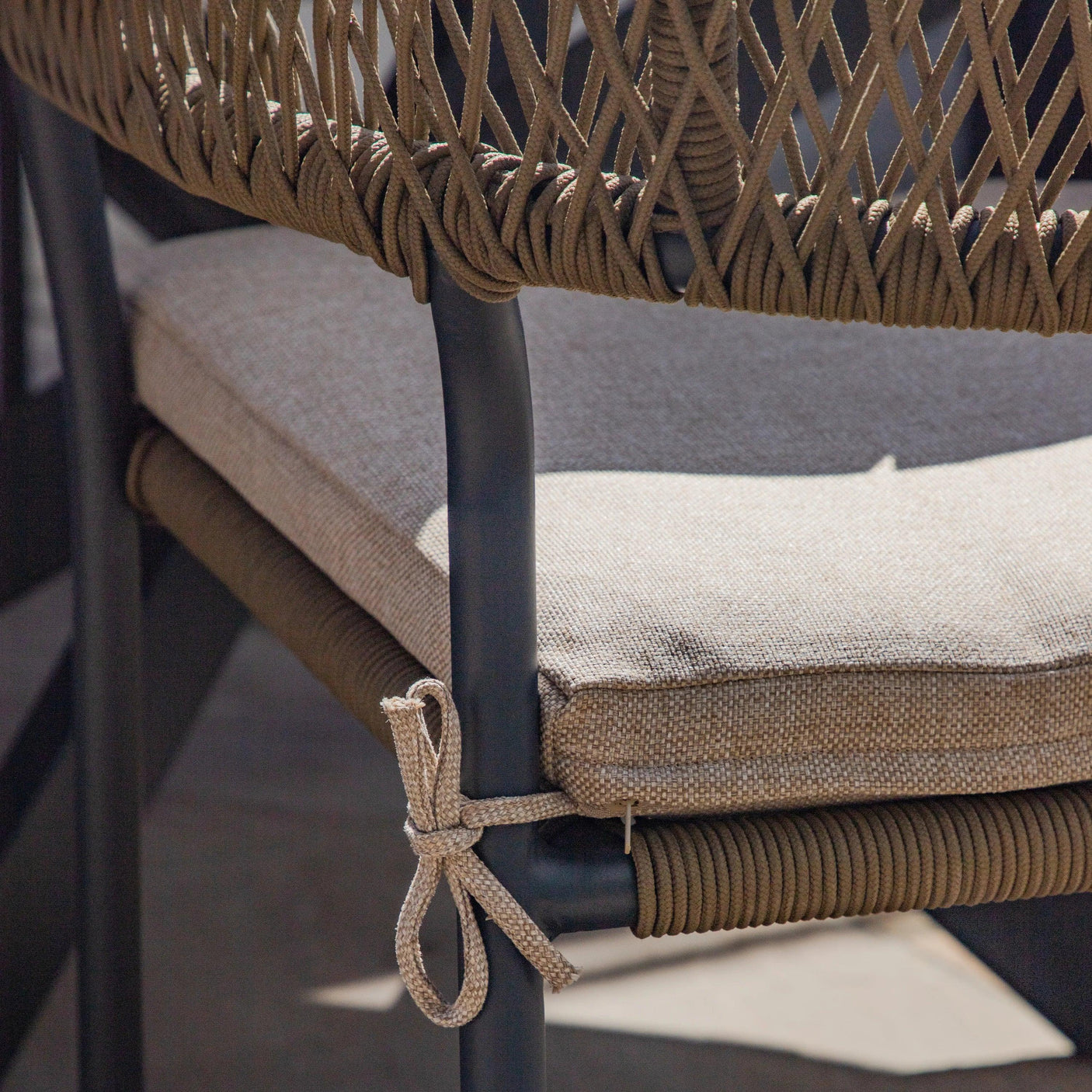 Outdoor dining chair with taupe rope back and beige cushion detail