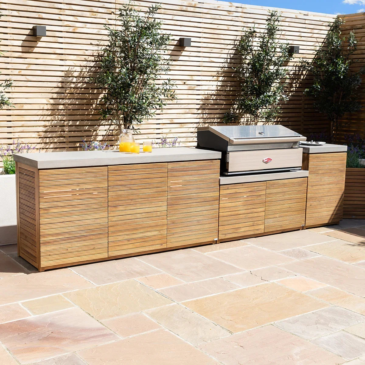 Outdoor kitchen unit with wood slat cabinets and built-in stainless steel barbecue grill