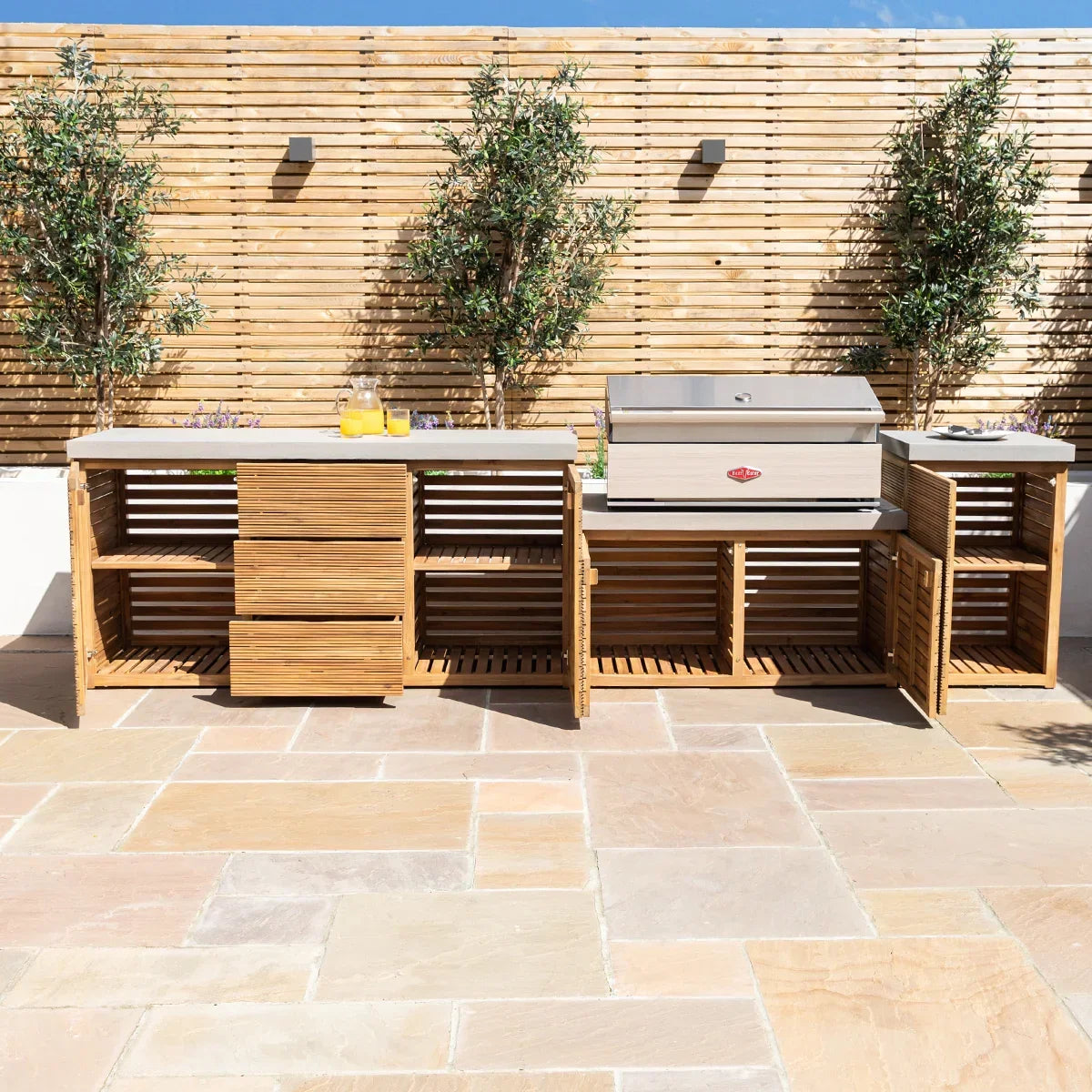 Outdoor wooden kitchen unit with storage shelves and built-in barbecue grill on patio