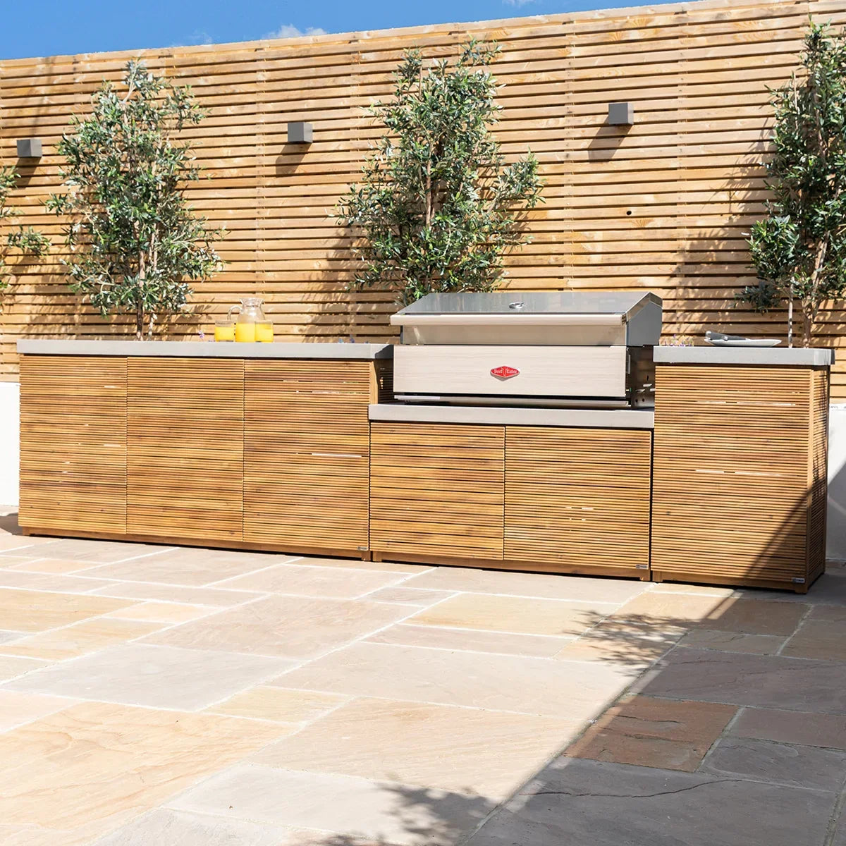 Outdoor kitchen unit with wood panel cabinets and built-in stainless steel gas barbecue grill