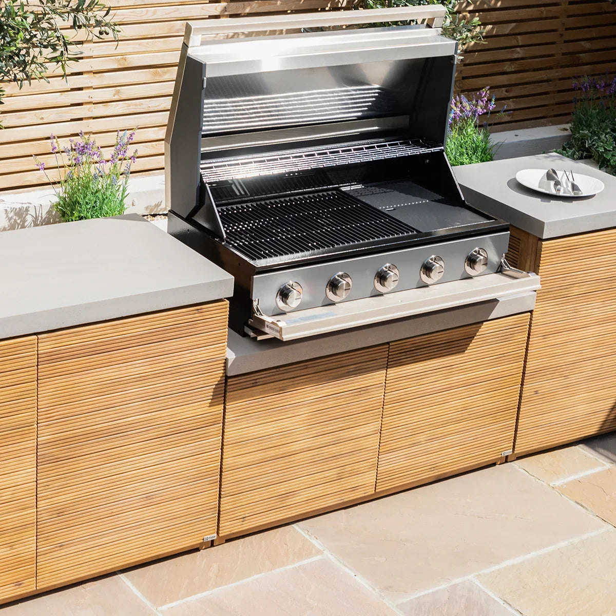 Stainless steel outdoor gas barbecue grill with wood cabinets and stone countertops
