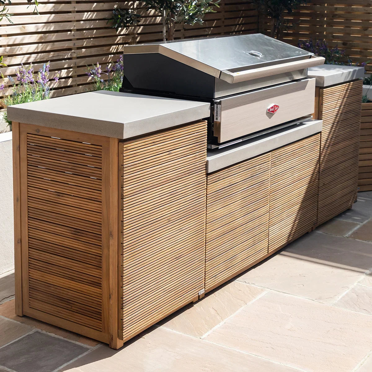 Outdoor kitchen unit with wood slat cabinets, stone countertop and built-in barbecue grill