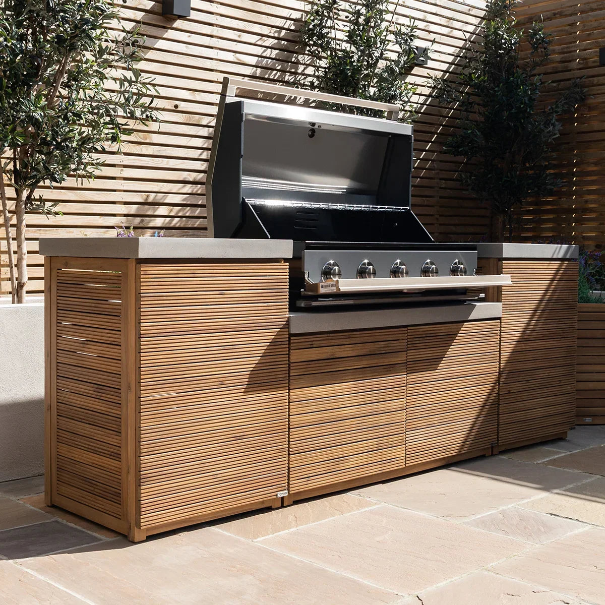 Outdoor kitchen with wooden slatted cabinets and stainless steel gas barbecue grill