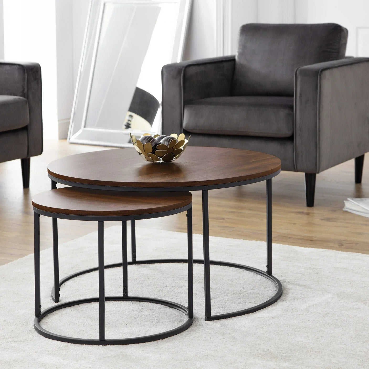 Walnut nest of coffee tables with black metal legs in modern living room setting