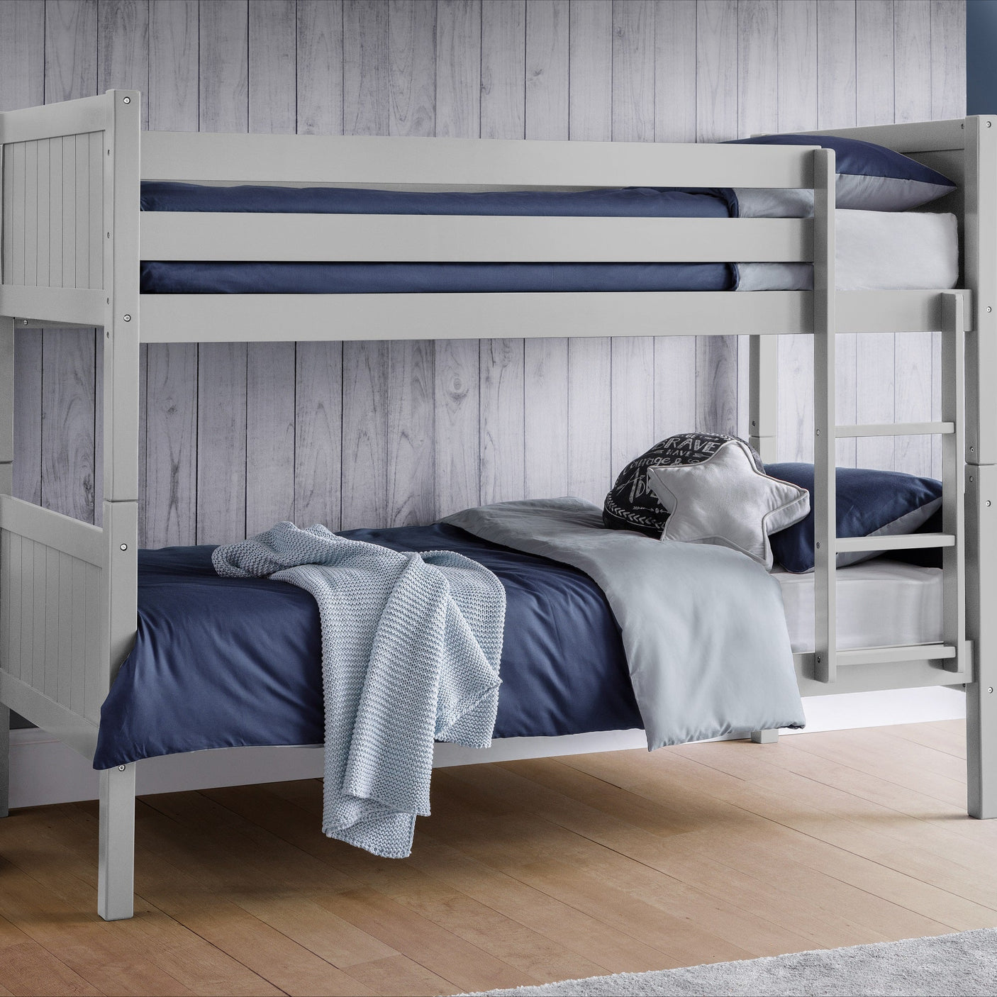 Dove grey wooden bunk bed with navy bedding and ladder against wood panelled wall