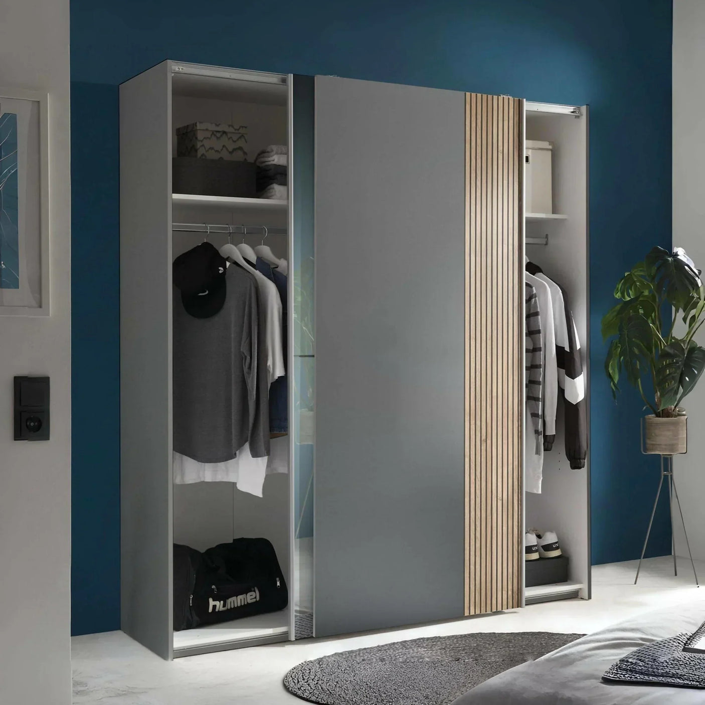 Grey sliding door wardrobe with wooden panel detail, open to show shelves and hanging rail