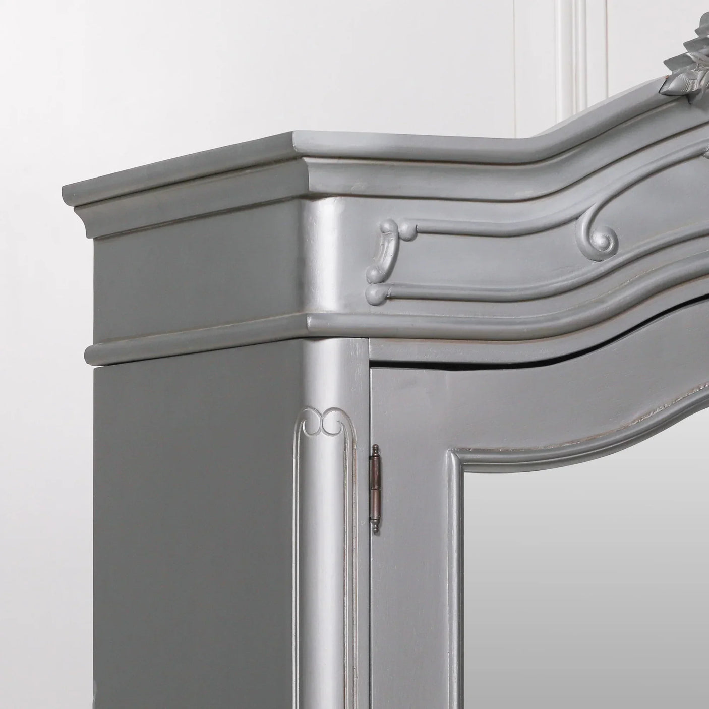Grey painted wardrobe with ornate wood trim and mirror door detail