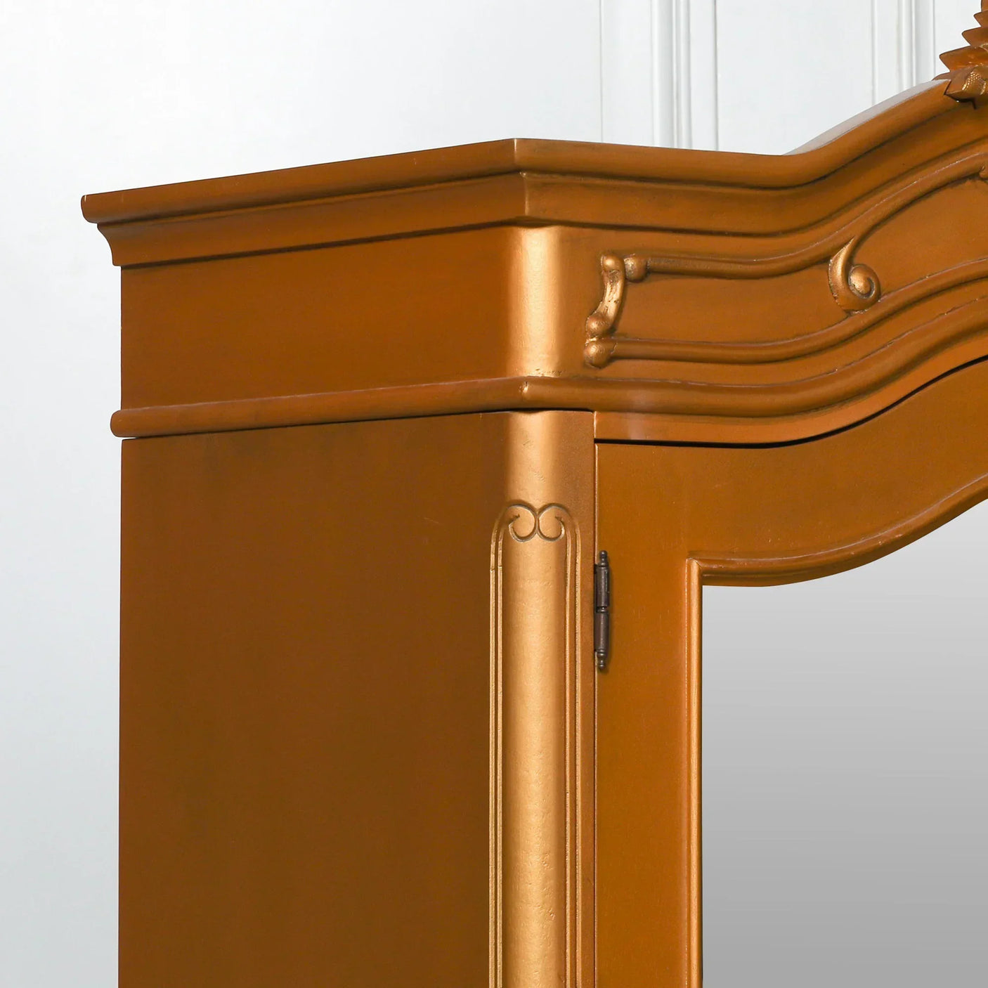 Close-up of gold wardrobe corner with ornate trim and wood detailing