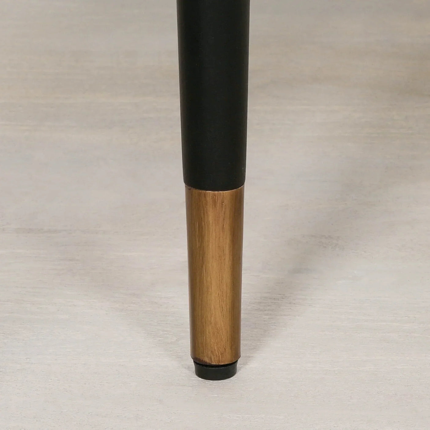 Close-up of metal and wood table leg on light wooden floor