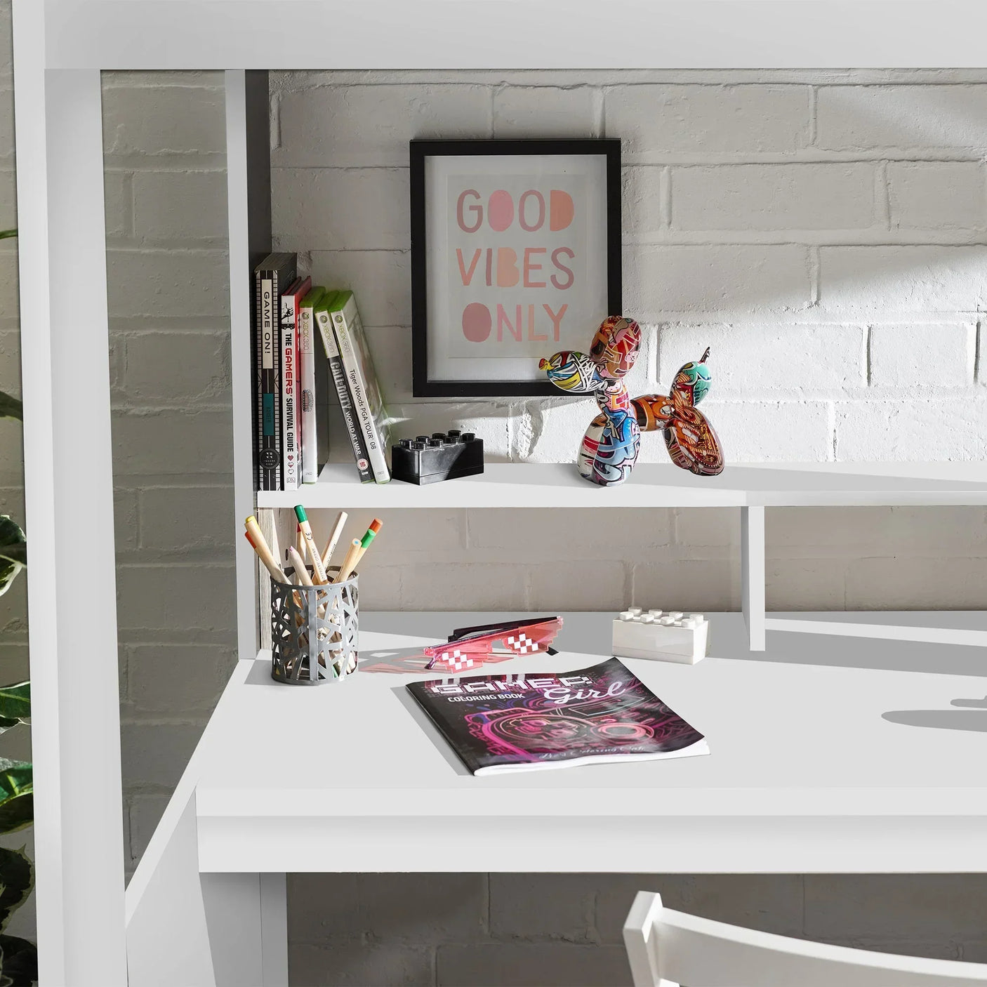 White gaming highsleeper desk with storage shelves, books, decor and stationery visible