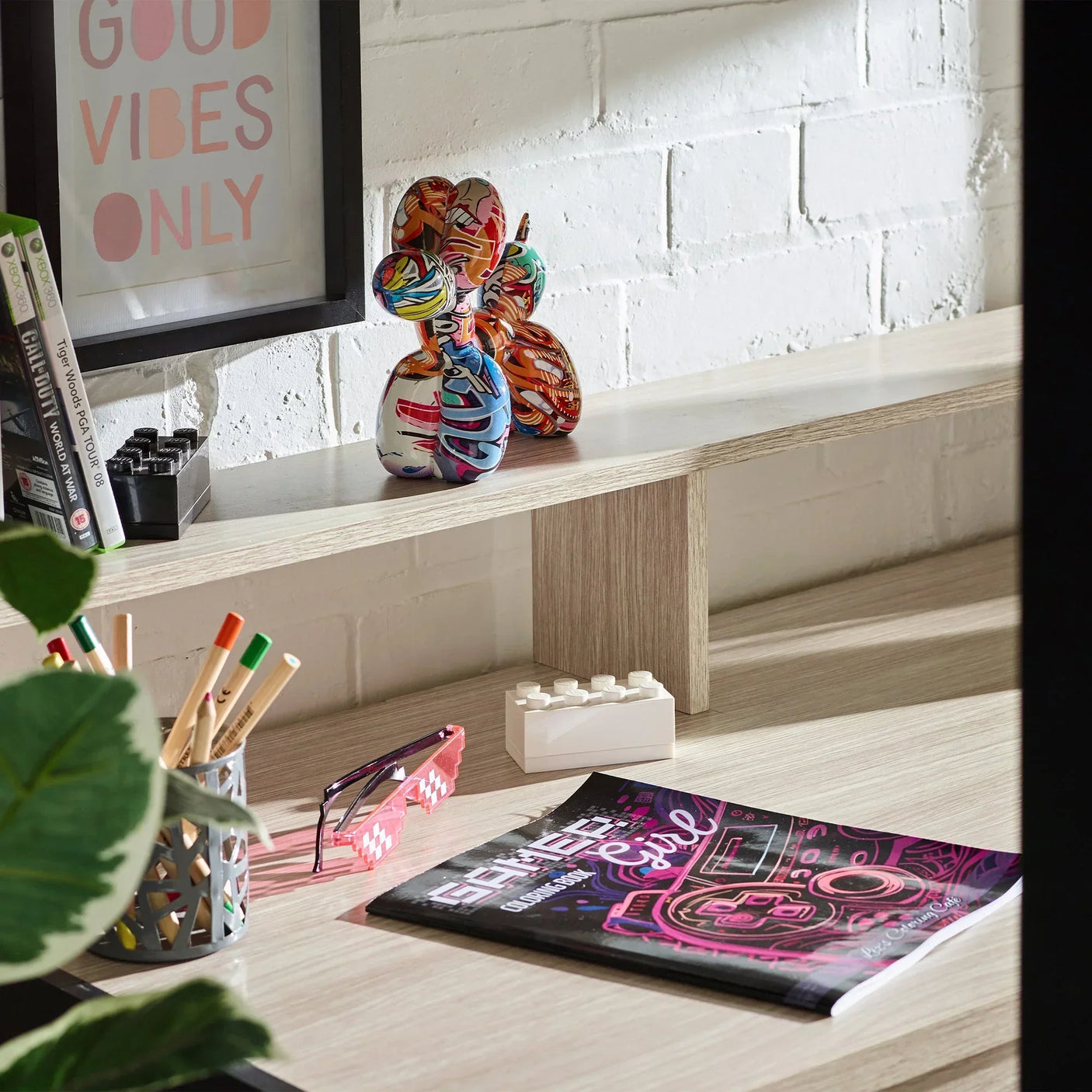 Pale wood gaming highsleeper desk with stationery, decor and colorful art figure
