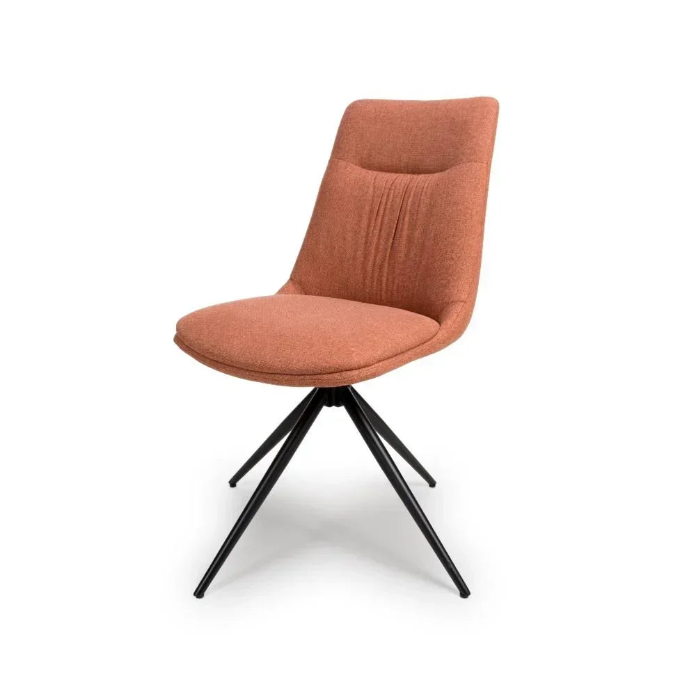 Rust fabric dining chair with cushioned seat and black metal legs, angled front view