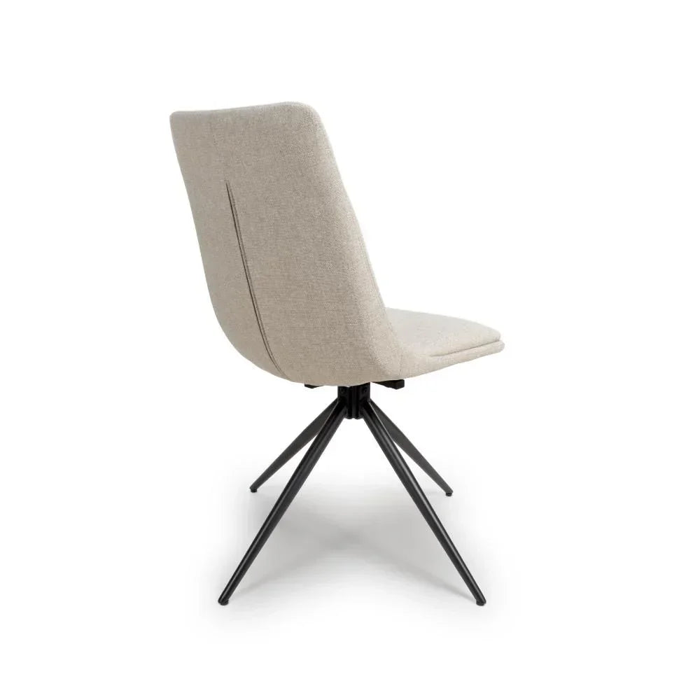 Beige fabric dining chair with black metal legs, rear angle view
