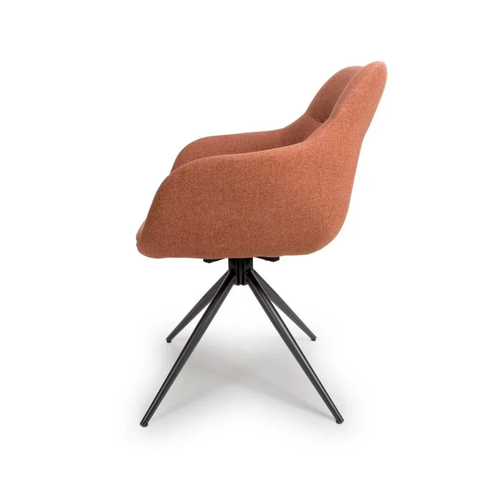 Side view of modern upholstered dining chair with rust fabric and black metal legs