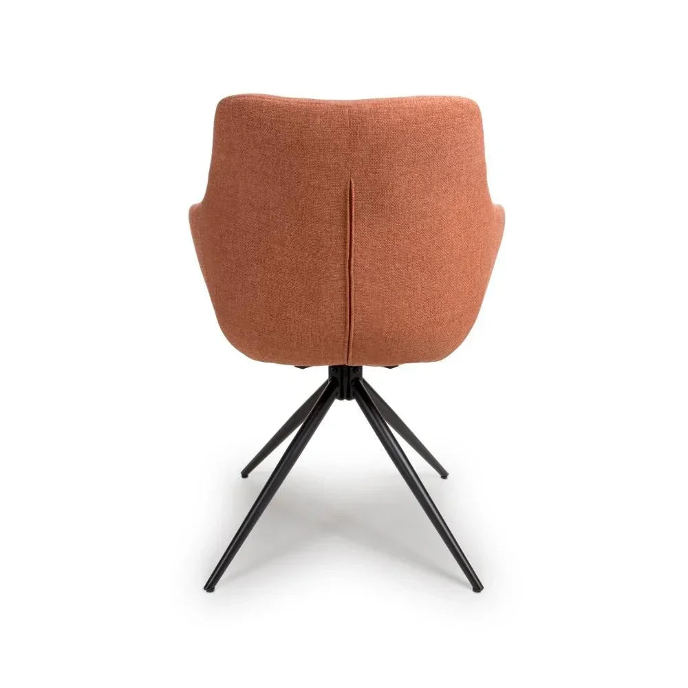 Rust fabric swivel dining chair with black metal legs, back view