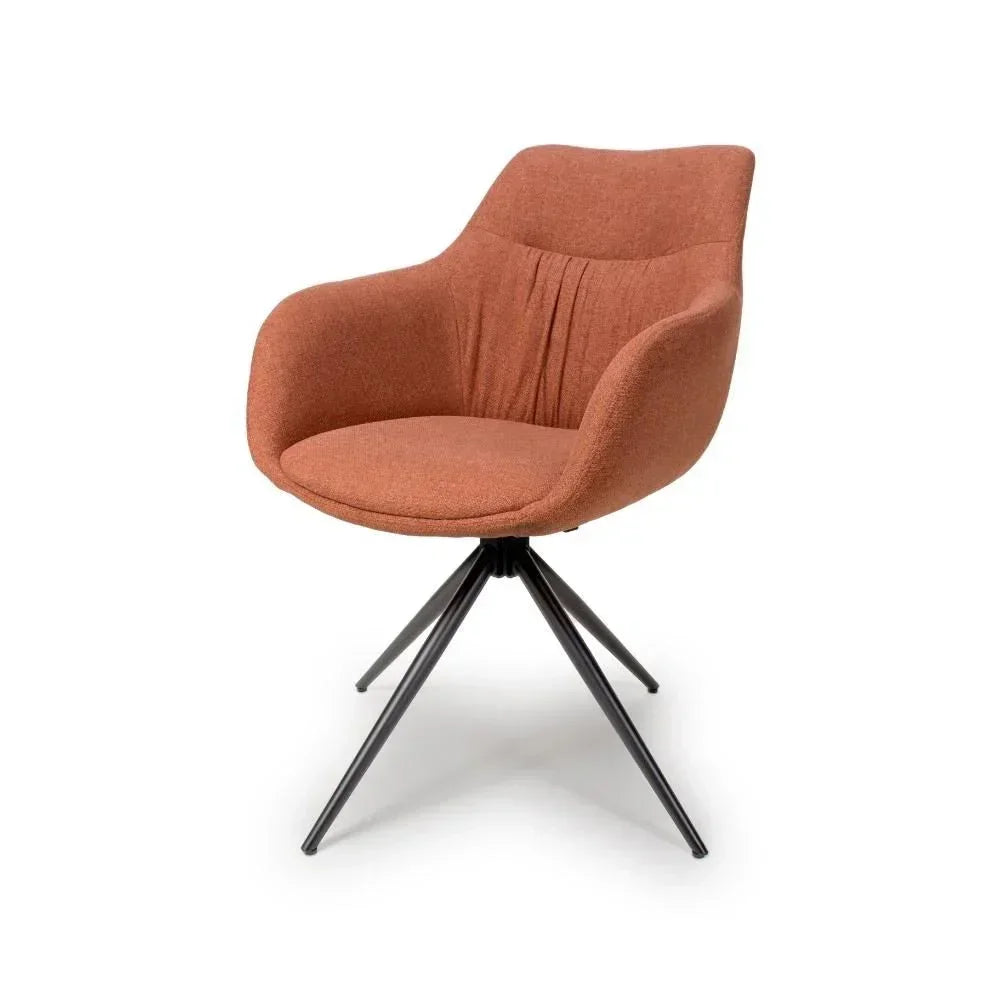 Rust fabric accent chair with curved armrests and black metal legs on white background