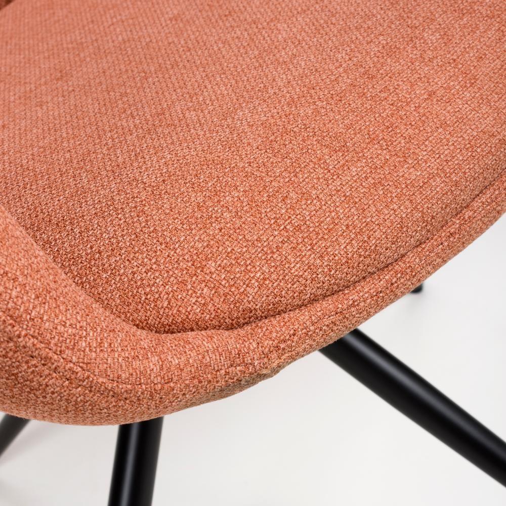 Close-up of textured orange fabric dining chair seat with black metal legs
