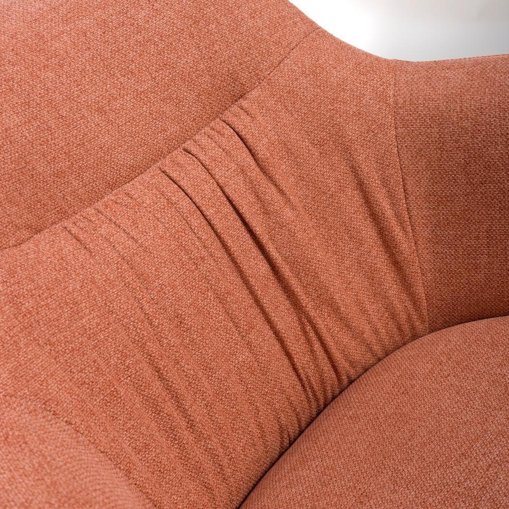 Rust fabric armchair close-up showing curved backrest and stitched upholstery details