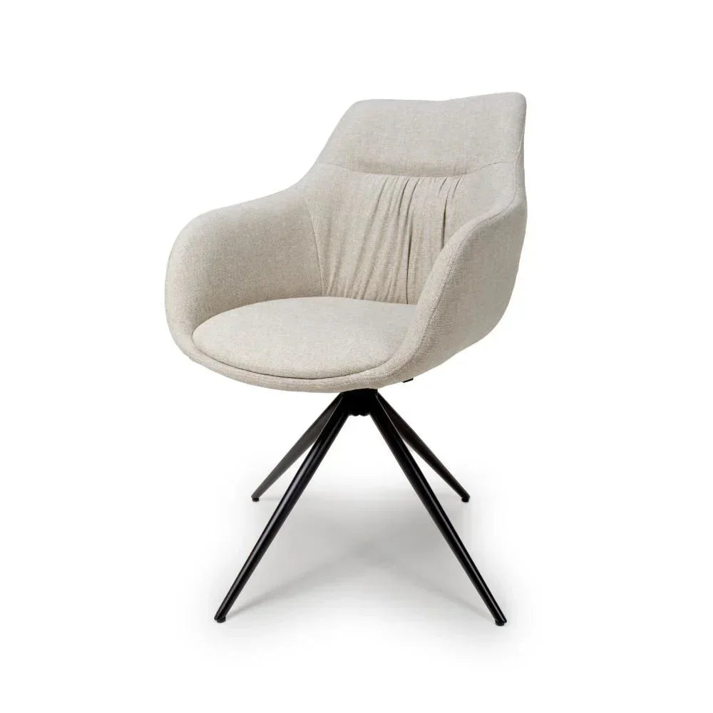 Beige fabric accent chair with curved backrest and black metal legs on white background