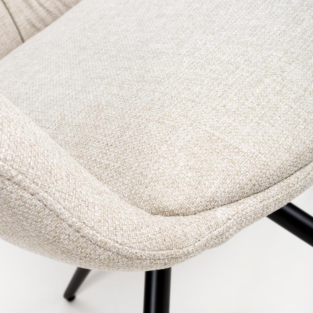 Beige fabric dining chair seat with curved cushion and black metal legs, close-up view