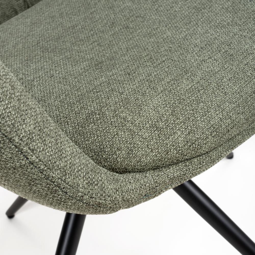 Close-up of green fabric dining chair seat with black metal legs