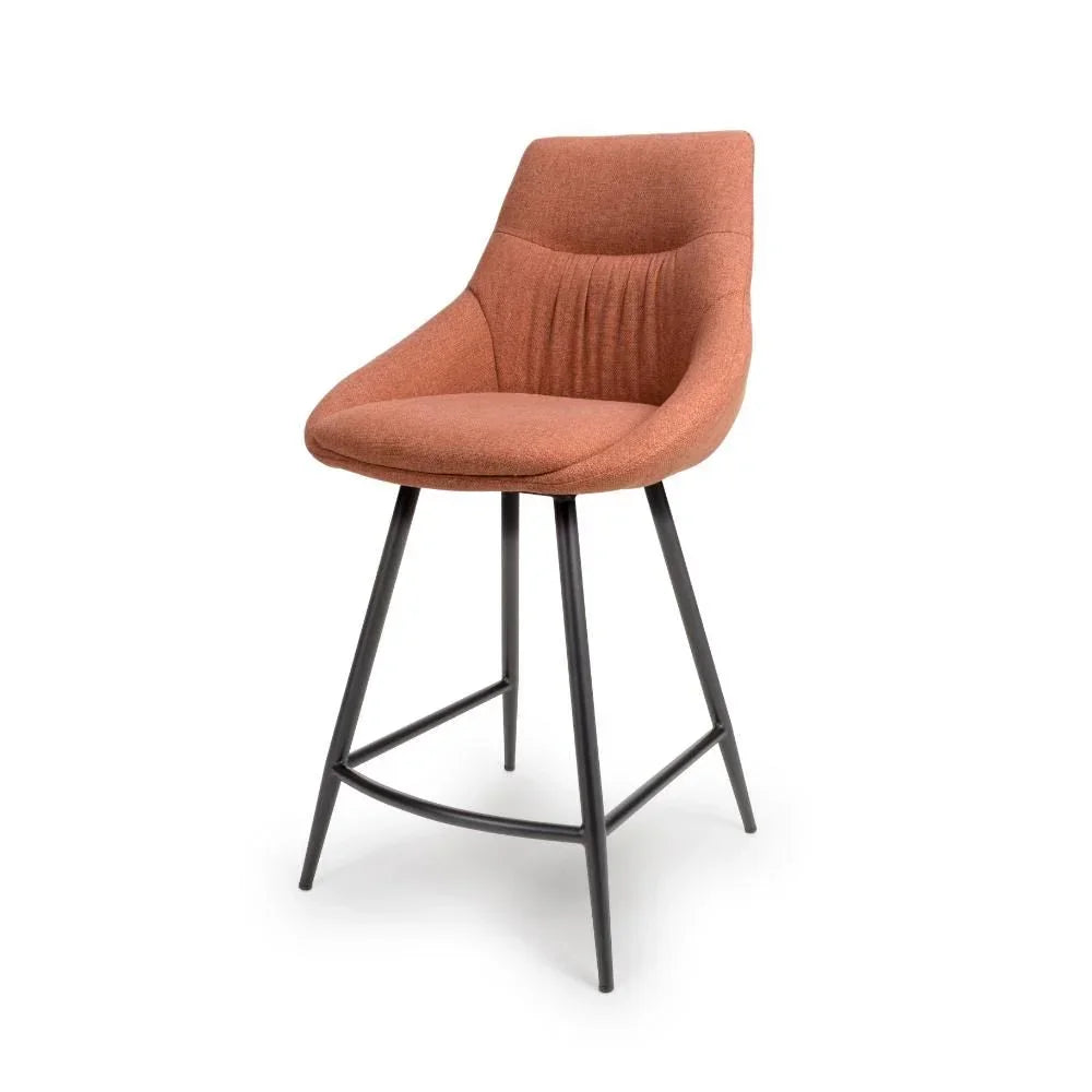 Rust upholstered bar stool with curved backrest and black metal legs