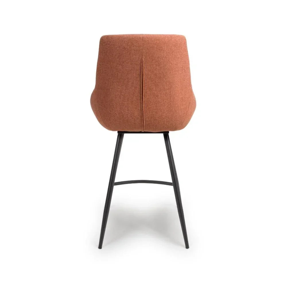 Rust fabric bar stool with curved backrest and black metal legs, rear view