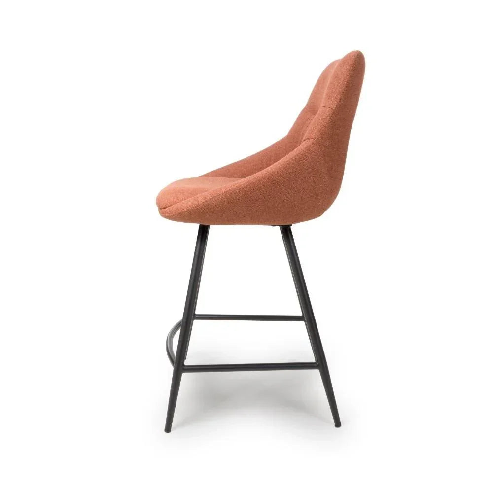 Rust fabric bar stool with padded seat and black metal legs, side view