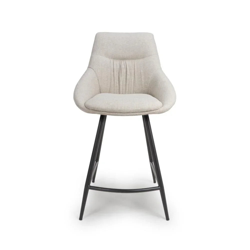 Beige upholstered bar stool with curved backrest and black metal legs, front view