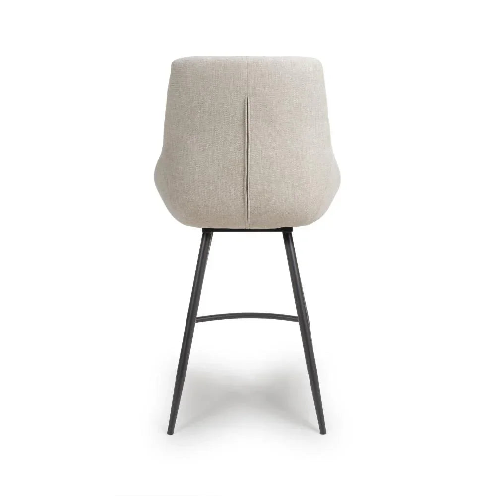 Beige fabric bar stool with black metal legs rear view