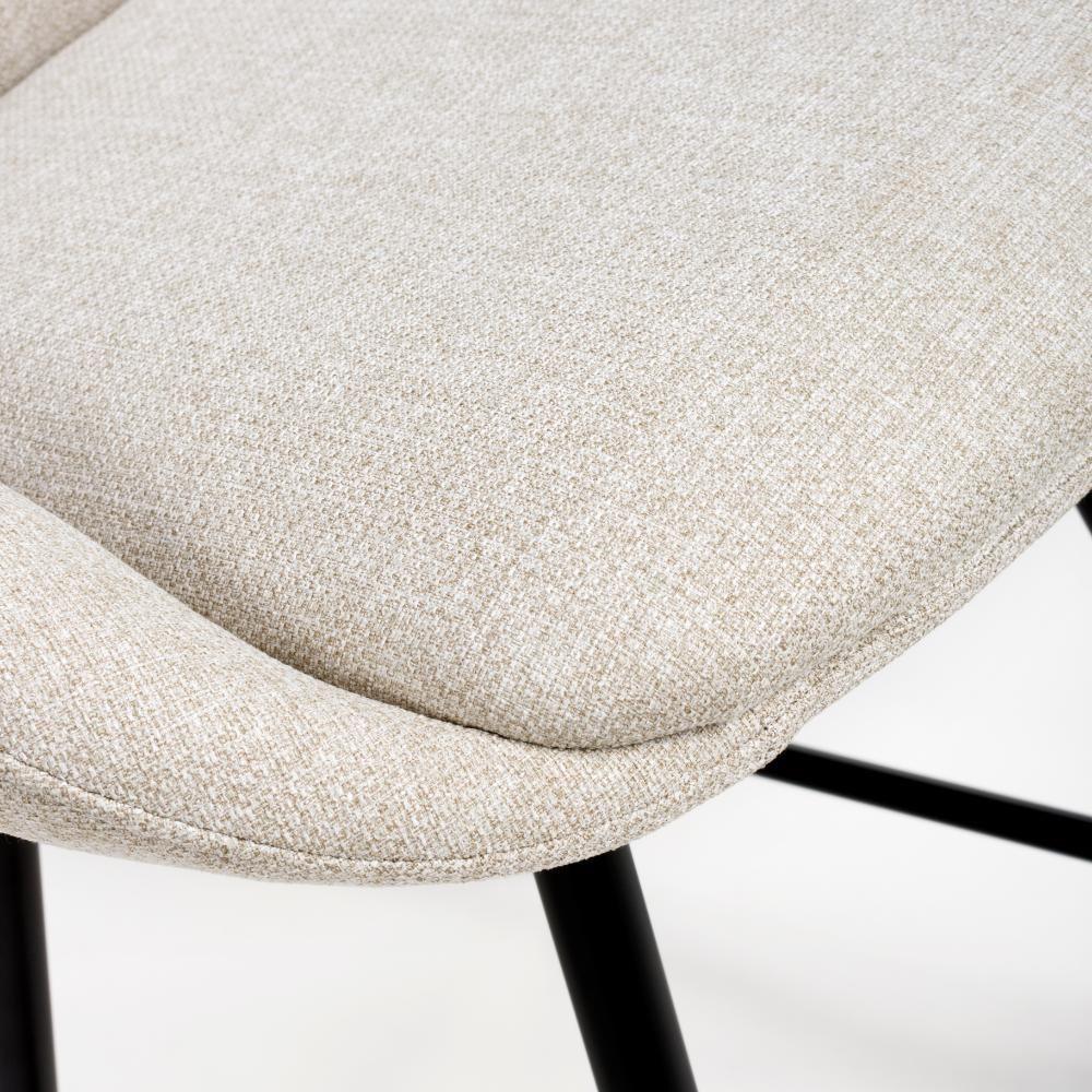 Close-up of beige fabric dining chair seat with black metal legs