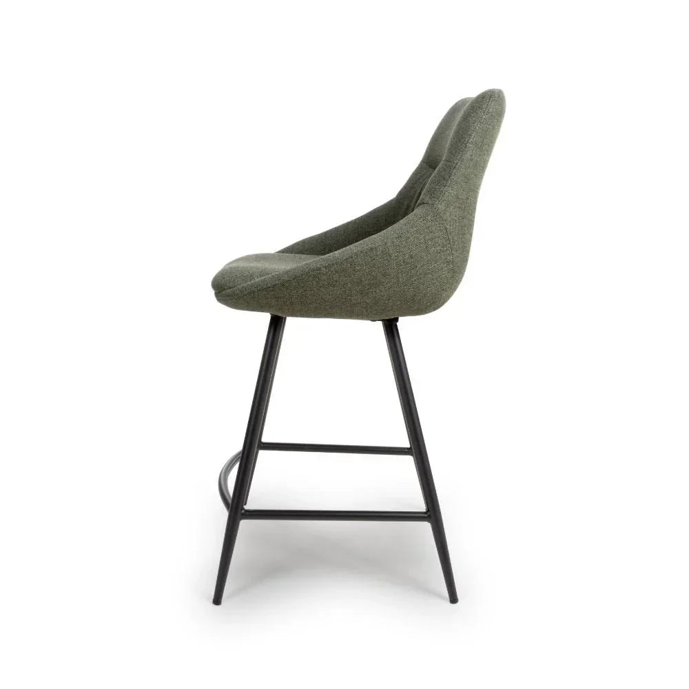 Side view of green fabric bar stool with curved backrest and black metal legs